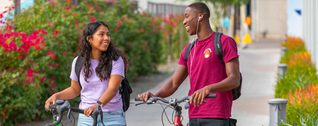 Two college students riding bikes.