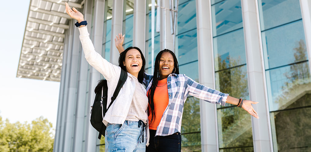 students taking picture in front of campus building