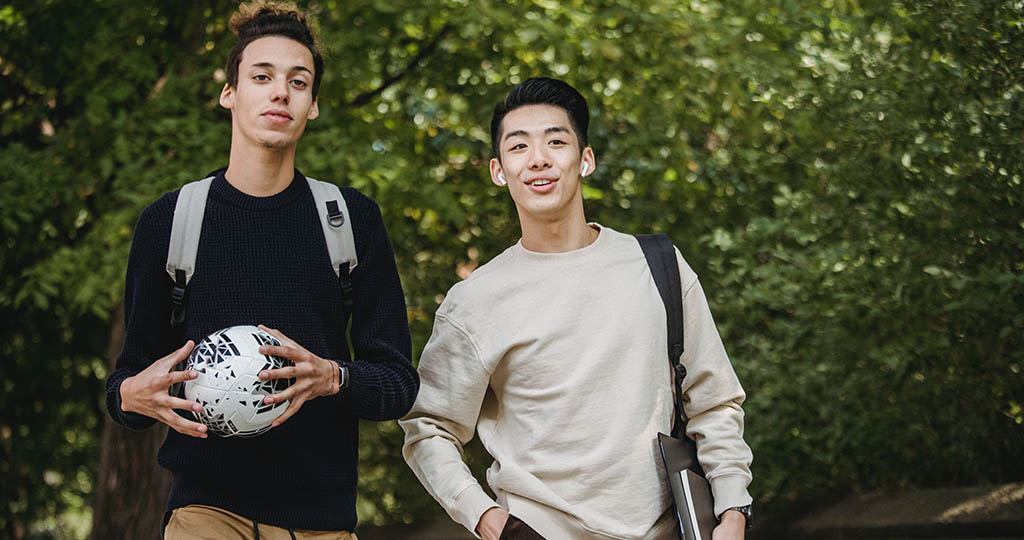 Two student athletes walking around their college campus.