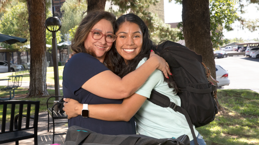 Mother and daughter embrace on college move in day.