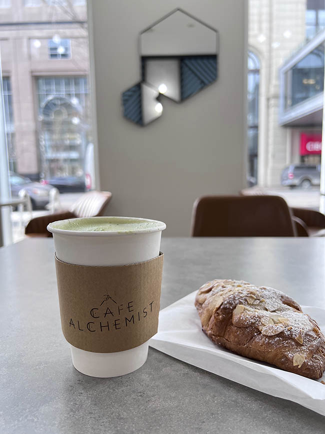 green matcha tea and almond croissant from cafe alchemist