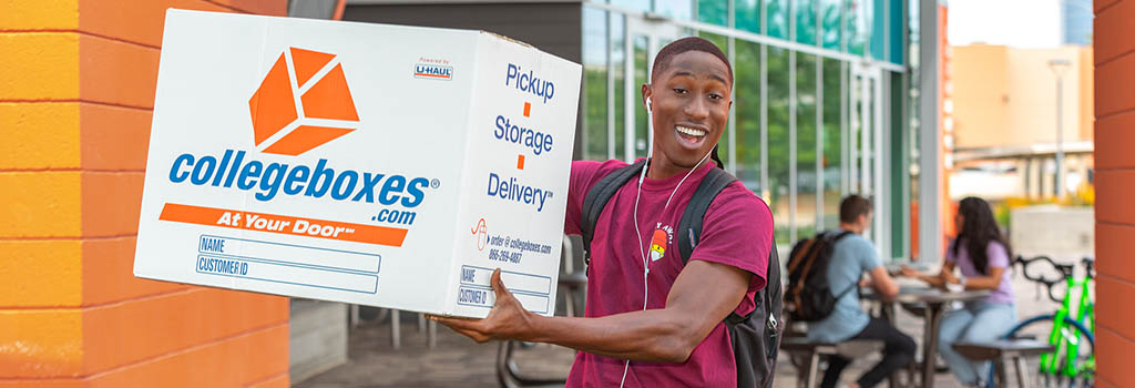 University student holding up a Collegeboxes college shipping box