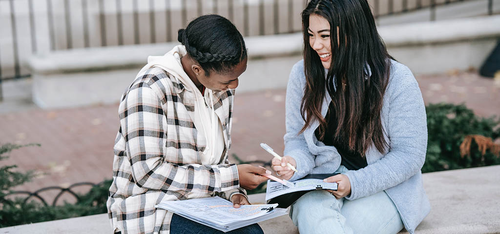 College Students sitting and studying on bench