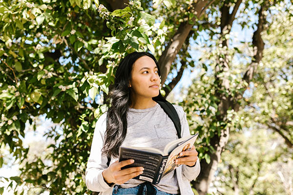 College student standing with book