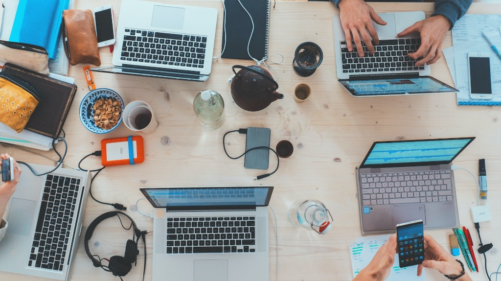 A table filled with laptops and electronics.