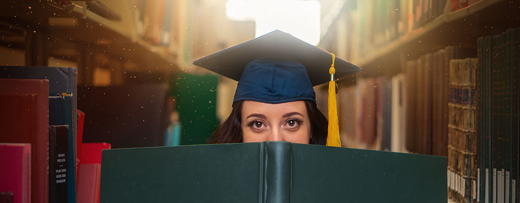 NAU graduate holding book