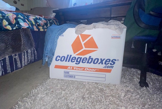A Collegeboxes box filled with clothes.