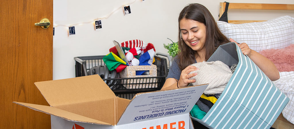 College student loading items into a Collegeboxes box