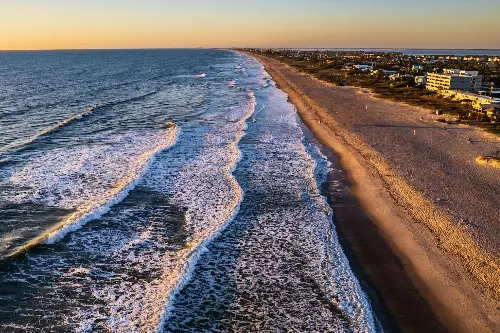 Waves crashing onto the shores at sunset.