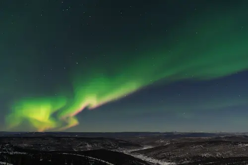 Dark sky with a bright green Northern Lights.