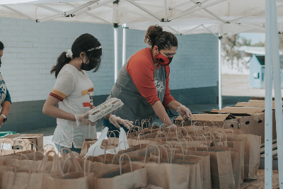 Two students packing up bags to hand out to those in need