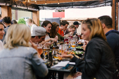 Group of people eating around an outdoor table