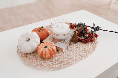 White table with tiny pumpkins, candles, and branches.