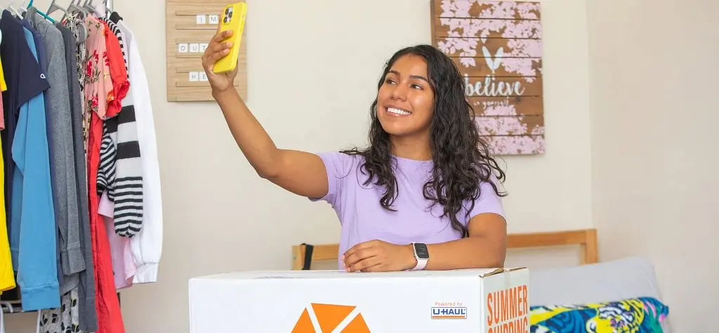 Girl posing for a selfie in front of a Collegeboxes box