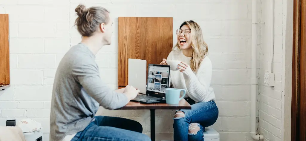 Man and woman sitting at a table and laughing