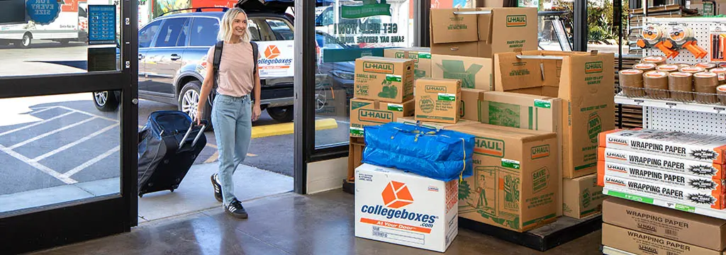 student entering a U-Haul Collegeboxes center with their belongings
