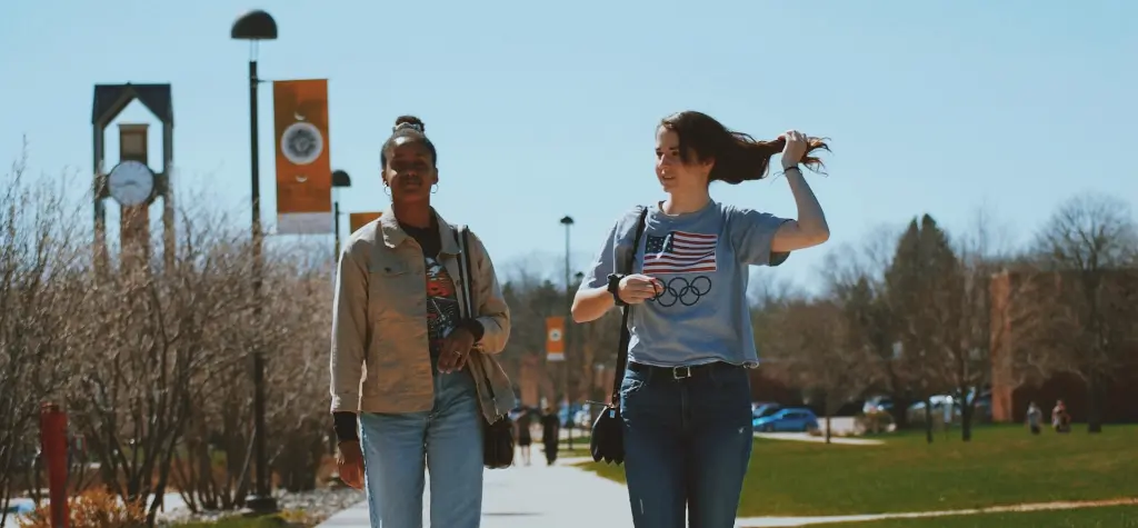 Two girls walking across campus