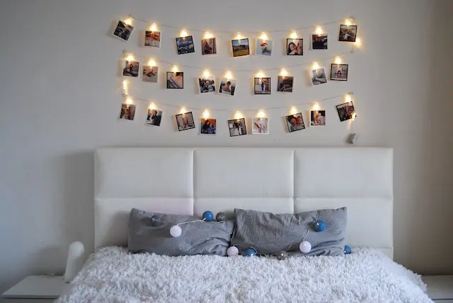 LED lights and pictures hanging above a bed