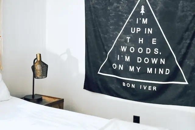 Bon Iver poster hanging on a blank white wall