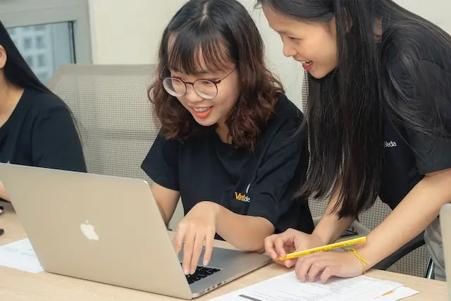 Student and teacher looking at a laptop