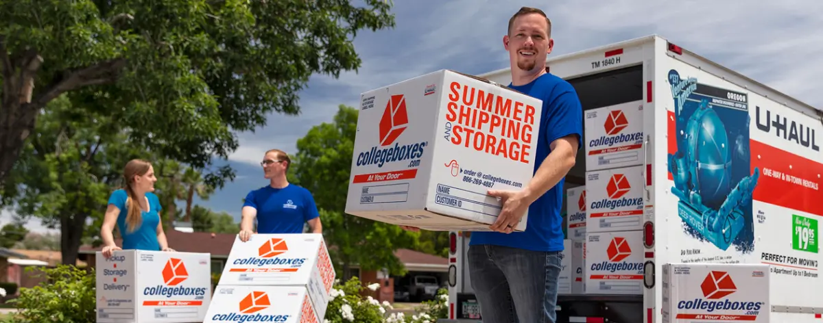 Three movers surrounded by CollegeBoxes branded boxes and a U-Haul truck.