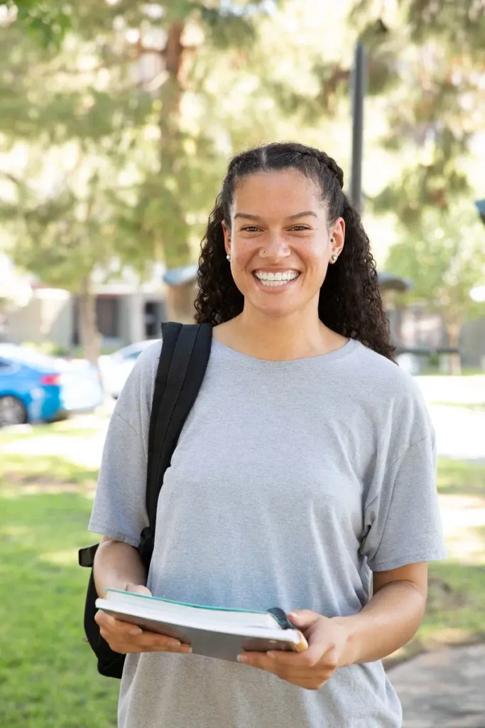 Girl standing outside and holding a book