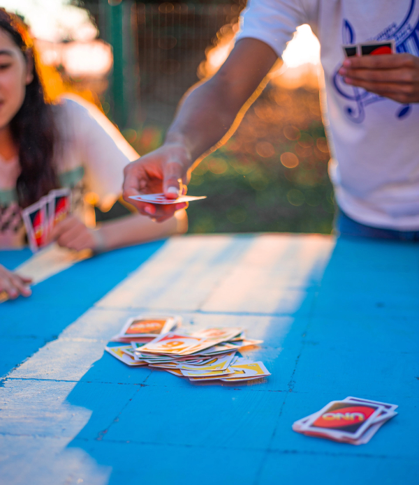 Two people playing a card game at an outside table