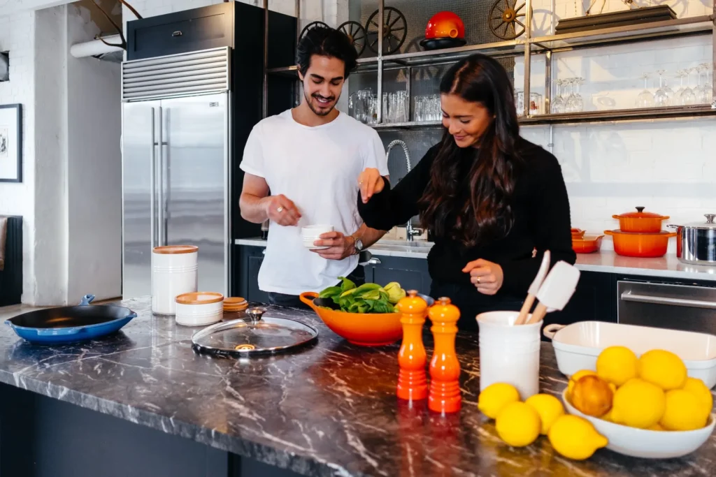 A man and woman preparing dinner on a counter