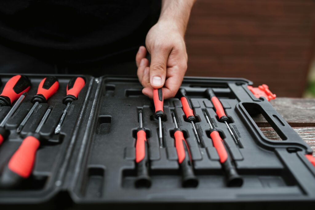 Hand placing a tool back in a toolbox