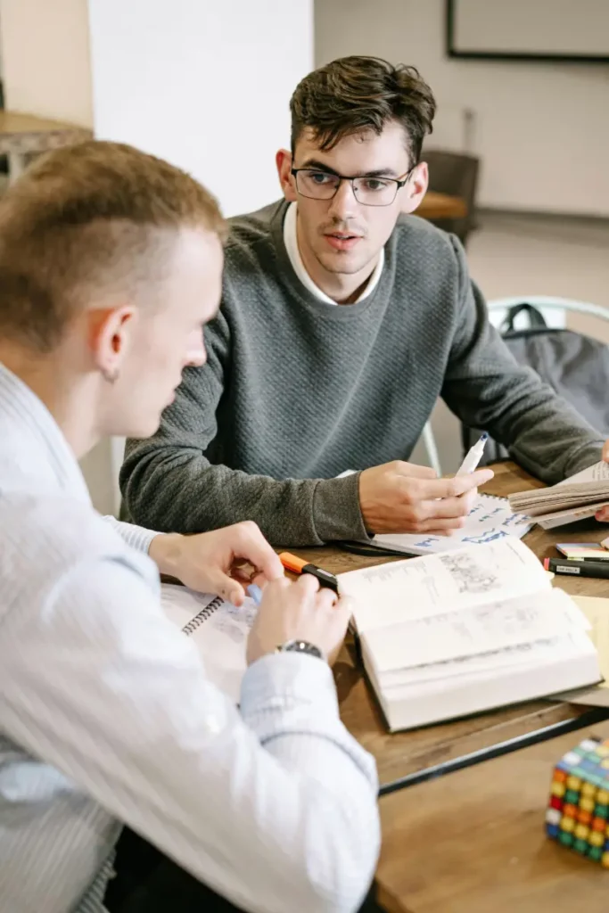 Two men stitting at a table reviewing notes