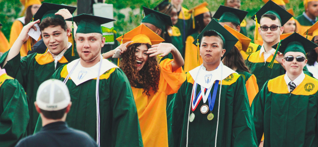 Graduates walking in a group, smiling.