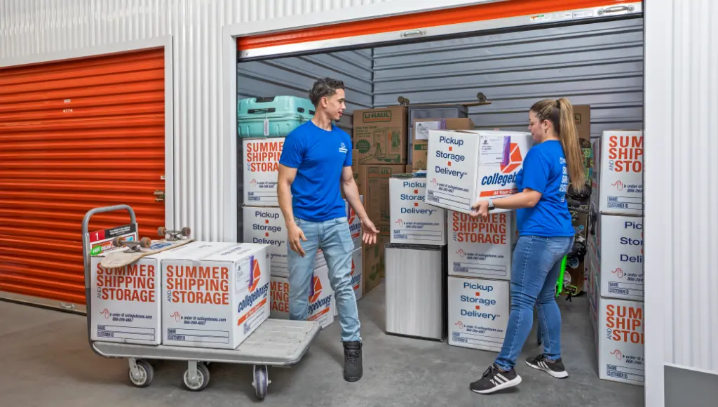 Movers loading boxes into a storage unit.