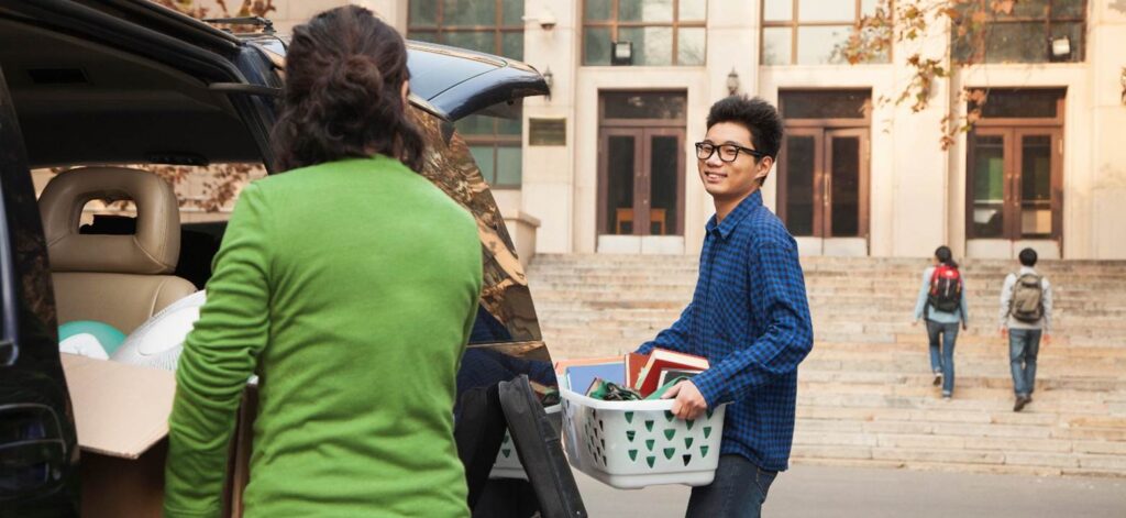 Kid loading a plastic tote moving out of college